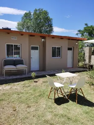 a table and chairs in front of a house at Complejo Serena in Santa Rosa de Calamuchita
