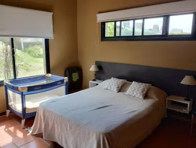 a bedroom with a large bed and a window at HolaViajerosVGB in Villa General Belgrano