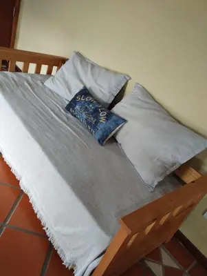 a bed with three pillows on top of it at HolaViajerosVGB in Villa General Belgrano