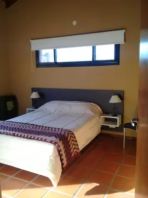 a bedroom with a large bed with a window at HolaViajerosVGB in Villa General Belgrano