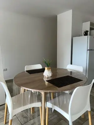 a dining room table with white chairs and a refrigerator at Cba Rent in Cordoba