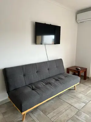 a couch in a room with a tv on the wall at Cba Rent in Cordoba