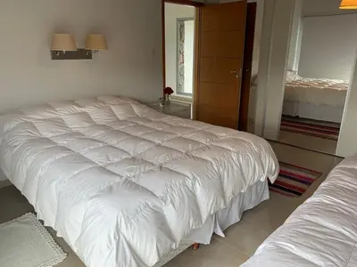 a bedroom with a large white bed in a room at La Cumbrecita ,Casona super Lujo . in La Cumbrecita