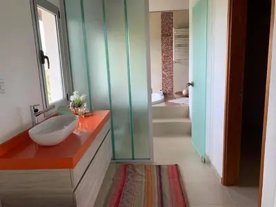 a bathroom with a white sink on a red counter at La Cumbrecita ,Casona super Lujo . in La Cumbrecita