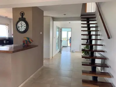 a staircase in a house with a clock on the wall at La Cumbrecita ,Casona super Lujo . in La Cumbrecita