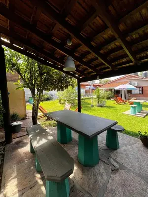 a picnic table and two benches under a pavilion at Complejo LA MERLINA in Merlo