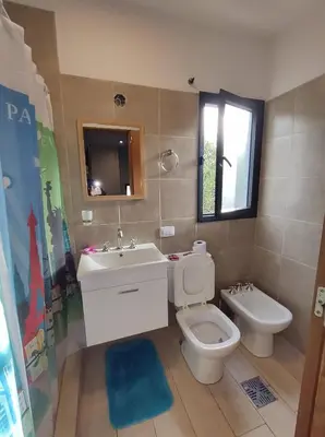 a bathroom with a sink and a toilet and a window at Complejo Claret, Departamentos a metros de Sanatorio Allende y Hospital Privado Cerro in Cordoba