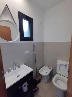 a bathroom with a sink and a toilet and a mirror at Complejo Claret, Departamentos a metros de Sanatorio Allende y Hospital Privado Cerro in Cordoba