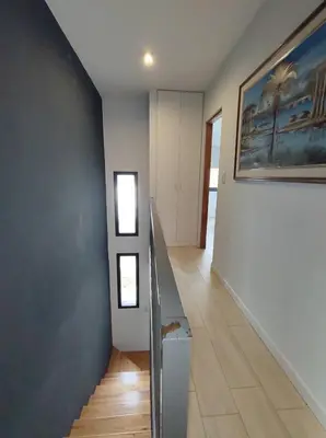 a hallway with a staircase and a painting on the wall at Complejo Claret, Departamentos a metros de Sanatorio Allende y Hospital Privado Cerro in Cordoba