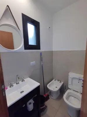 a bathroom with a sink and a toilet and a mirror at Complejo Claret, Departamentos a metros de Sanatorio Allende y Hospital Privado Cerro in Cordoba