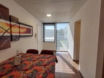a room with a bed and two chairs in it at Complejo Claret, Departamentos a metros de Sanatorio Allende y Hospital Privado Cerro in Cordoba
