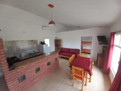 a living room with a brick fireplace and a red couch at El Atardecer in Cortaderas