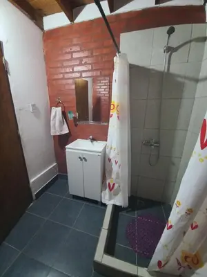 a bathroom with a shower curtain and a sink at El Atardecer in Cortaderas