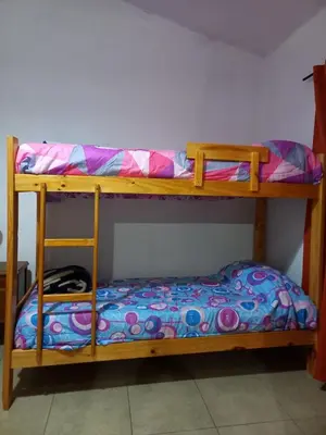 two bunk beds with a bed on the bottom level at El Atardecer in Cortaderas