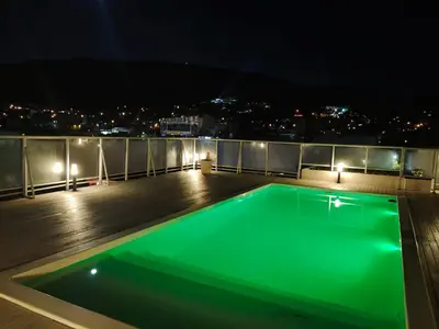 a green swimming pool on a roof at night at Apartamento Carlos Paz in Villa Carlos Paz