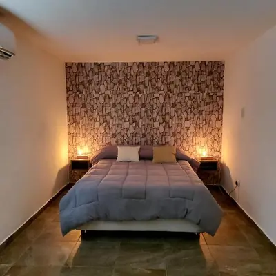 a bedroom with a large bed and two night stands at Altos del Monte in Villa Rumipal