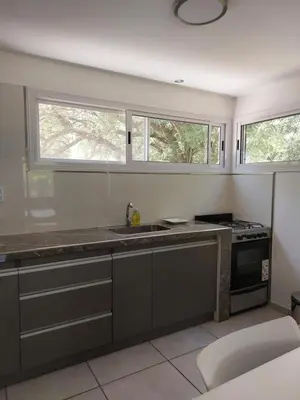 a kitchen with a sink and two windows at Altos del Monte in Villa Rumipal