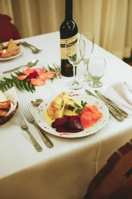 a table with a plate of food and a bottle of wine at Hotel Las Cascadas in La Cumbrecita