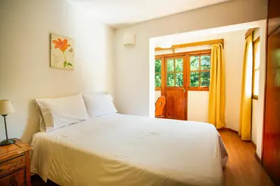 a bedroom with a white bed and a window at Hotel Las Cascadas in La Cumbrecita