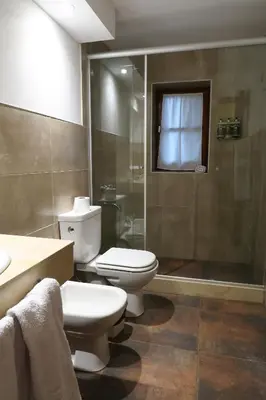 a bathroom with a toilet and a shower at Hotel Las Cascadas in La Cumbrecita