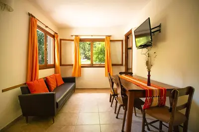 a living room with a couch and a dining room table at Hotel Las Cascadas in La Cumbrecita