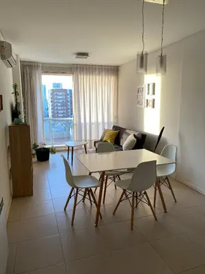 a living room with a table and chairs and a couch at Departamento céntrico - Leer condiciones y precio in Río Cuarto