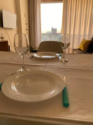 a table with a plate and two wine glasses on it at Departamento céntrico - Leer condiciones y precio in Río Cuarto