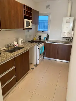 an empty kitchen with a sink and a microwave at Departamento céntrico - Leer condiciones y precio in Río Cuarto