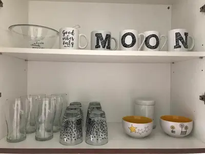 a shelf with glass vases and mocoons on it at Departamento céntrico - Leer condiciones y precio in Río Cuarto
