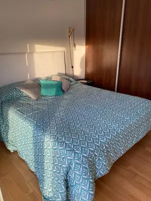 a bed with a blue comforter in a bedroom at Departamento céntrico - Leer condiciones y precio in Río Cuarto