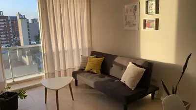 a living room with a couch and a window at Departamento céntrico - Leer condiciones y precio in Río Cuarto