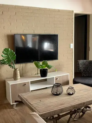 a living room with a tv and a coffee table at Casa Las Magnolias Villa General Belgrano in Villa General Belgrano