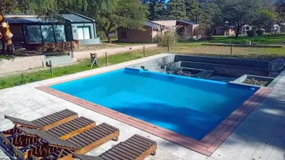 a large swimming pool with chairs around it at Casa Las Magnolias Villa General Belgrano in Villa General Belgrano