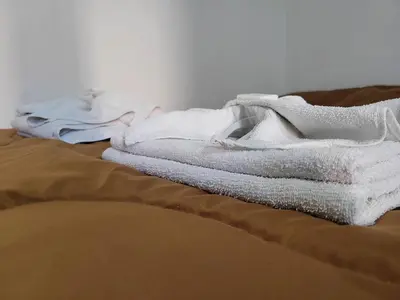 a pile of white towels sitting on top of a bed at Hotel Belgrano in Villa Carlos Paz