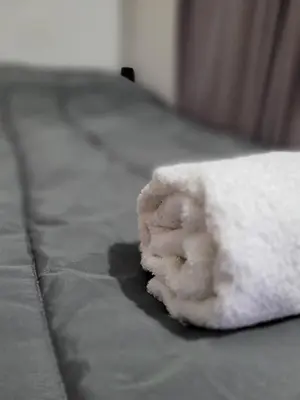 a white towel sitting on top of a bed at Hotel Belgrano in Villa Carlos Paz
