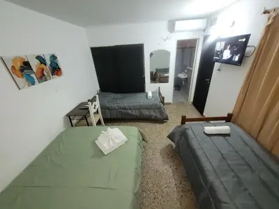 a small room with two beds and a couch at Hotel Belgrano in Villa Carlos Paz