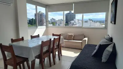a dining room with a table and chairs and a couch at Torre del Lago VI in Villa Carlos Paz