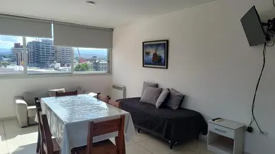 a room with a bed and a table and a television at Torre del Lago VI in Villa Carlos Paz