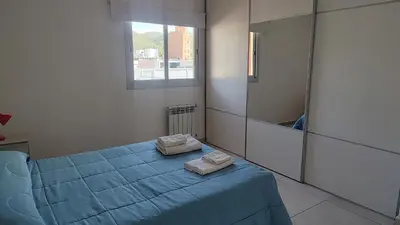 a bedroom with a blue bed and a mirror at Torre del Lago VI in Villa Carlos Paz