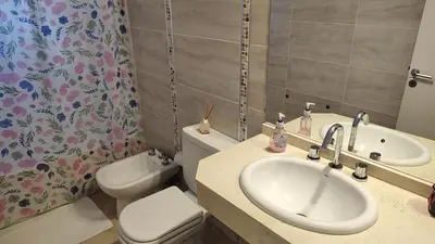 a bathroom with a sink and a toilet and a mirror at Torre del Lago VI in Villa Carlos Paz
