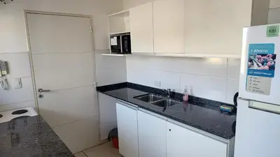 a white kitchen with a sink and a microwave at Torre del Lago VI in Villa Carlos Paz