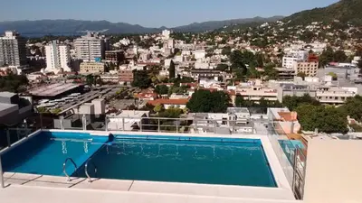 a swimming pool on top of a building with a city at Torre del Lago VI in Villa Carlos Paz