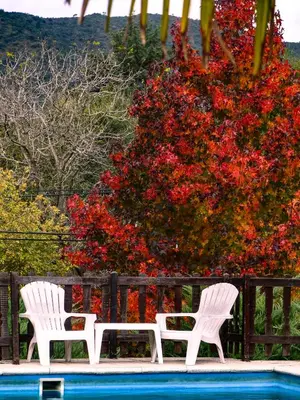 two white chairs sitting next to a swimming pool at Posada Yumei in Villa General Belgrano