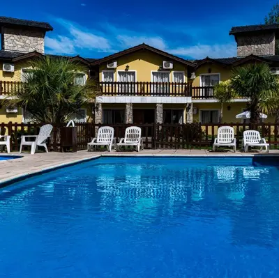 a pool with chairs and a house in the background at Posada Yumei in Villa General Belgrano