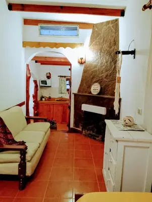 a living room with a couch and a fireplace at Aldea Granpas in Embalse