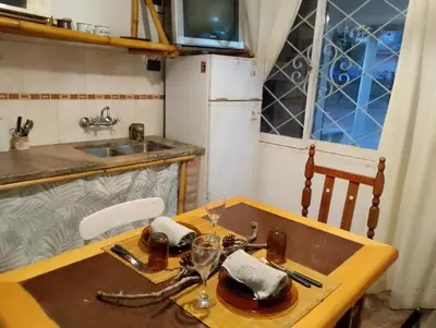 a small kitchen with a wooden table and a sink at Aldea Granpas in Embalse