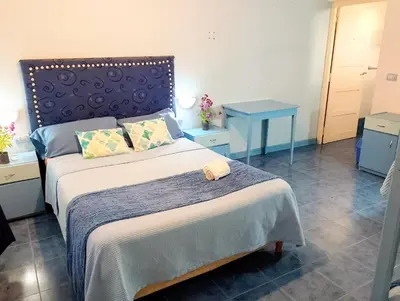 a bedroom with a large bed with a blue headboard at Aldea Granpas in Embalse