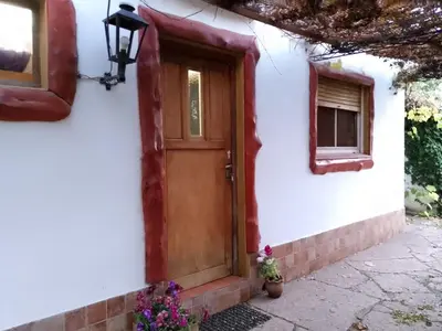 a white house with a wooden door and a window at Aldea Granpas in Embalse