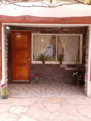 a front door of a brick house with flowers at Aldea Granpas in Embalse