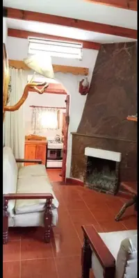 a living room with a fireplace and a couch at Aldea Granpas in Embalse